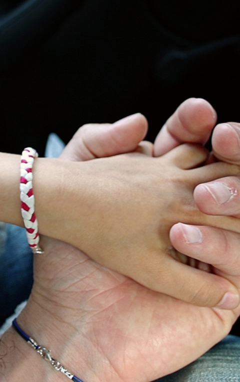 Kleine Kinderhand in erwachsener Hand